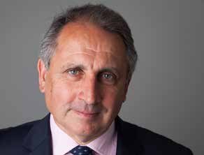 Headshot of a middle-aged white man with graying hair, wearing a suit and patterned tie.