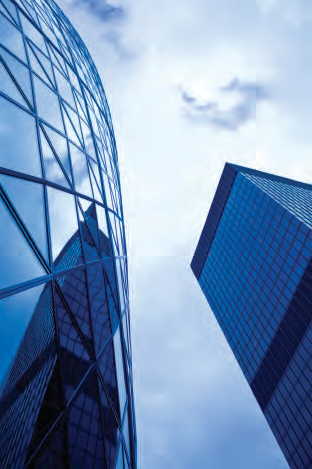 Low-angle view of two modern blue-tinted skyscrapers against a cloudy sky, one curved with a grid pattern, the other rectangular.