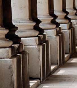 Close-up of a series of classical architectural columns with dark bases and white shafts, suggesting a historical building.