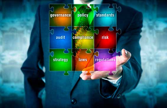 Man holding colorful puzzle pieces with business terms like governance, policy, standards, compliance, and risk, forming a conceptual framework.