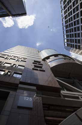 Low-angle view of a modern building exterior, showing the address number "125" on a lower wall.