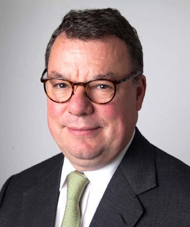 Headshot of a man with glasses, wearing a suit and tie.
