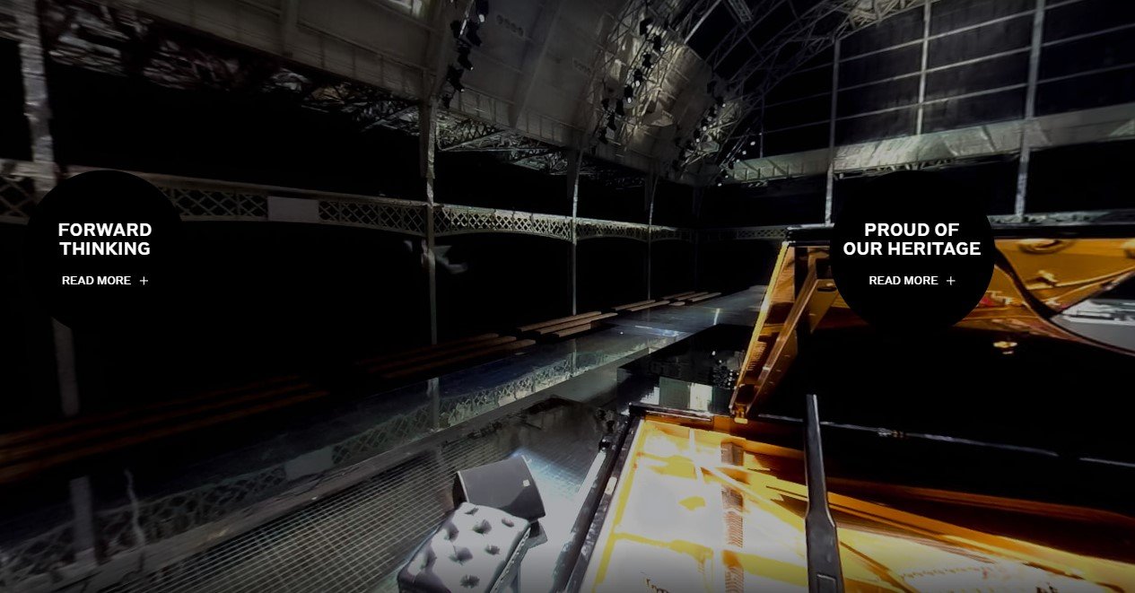 Dark, wide-angle interior photo of an industrial-style space acting as a backdrop for interactive concepts "Forward Thinking" and "Proud of our Heritage".