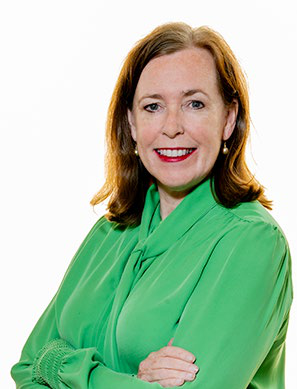 Headshot of a smiling woman with brown hair, wearing a green blouse.
