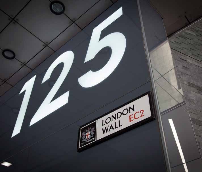 Close-up of a building sign displaying the address '125 London Wall EC2' with the City of London crest.