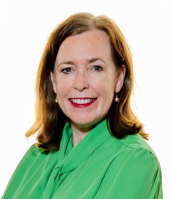 Headshot of a smiling woman with brown hair, wearing a green blouse.