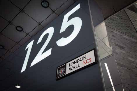 Building signage with large numbers '125' and a sign for 'London Wall EC2' with the City of London logo.