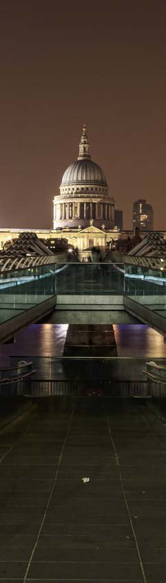 Panoramic night view of St Paul's Cathedral and its surroundings in London, with reflections on a modern structure.