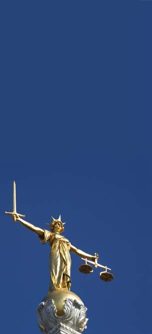 Golden statue of Lady Justice, blindfolded and holding a sword and scales, against a clear blue sky.