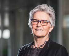 Portrait photo of a smiling woman with short gray hair and glasses, likely an executive or board member.