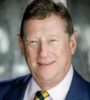 Headshot of a smiling man in a suit with a striped tie.