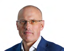 Headshot of a bald man with glasses wearing a blue jacket, likely an executive or board member.