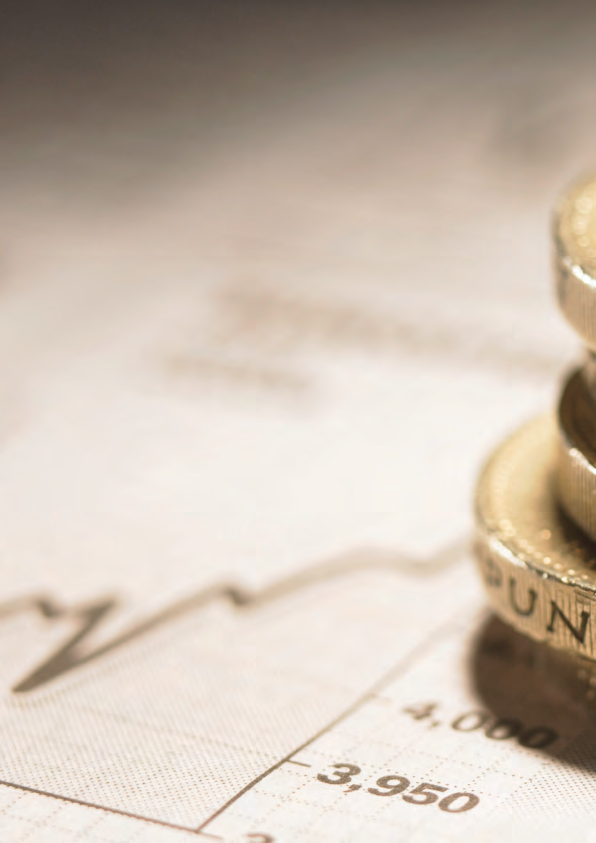 Stack of British Pound coins resting on a document displaying a financial graph line and numbers, indicating financial data.