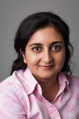 Headshot of a woman with long dark hair, wearing a pink collared shirt.
