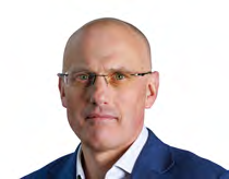 Headshot of a bald man with glasses wearing a blue jacket, likely an executive or board member.