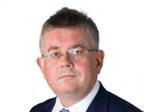Headshot of a man with glasses and a suit looking forward.