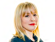 Headshot of a woman with blonde hair and red lipstick wearing a dark top.