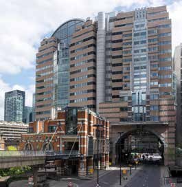View of a multi-story building with a large archway over a street, showing varied architecture.