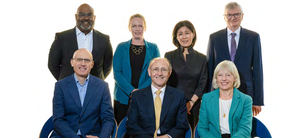 Group photo of eight professionals, likely a board or leadership team, in business attire.