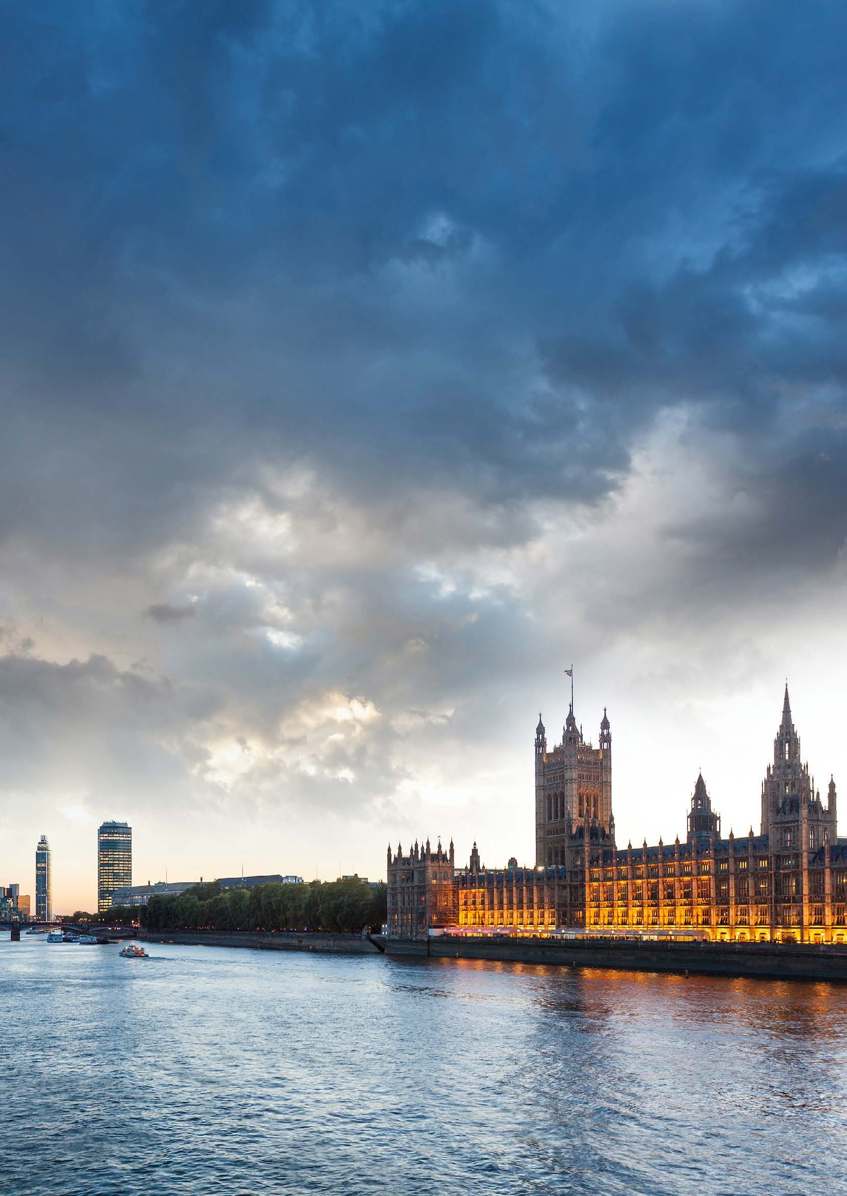 Houses of Parliament and the River Thames at dusk under a cloudy sky.