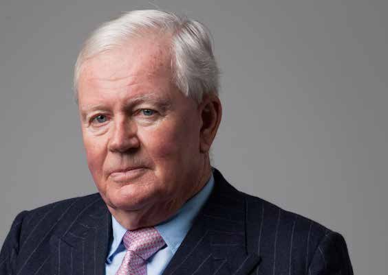 Headshot of an older man with white hair, wearing a dark pinstripe suit and light purple tie.