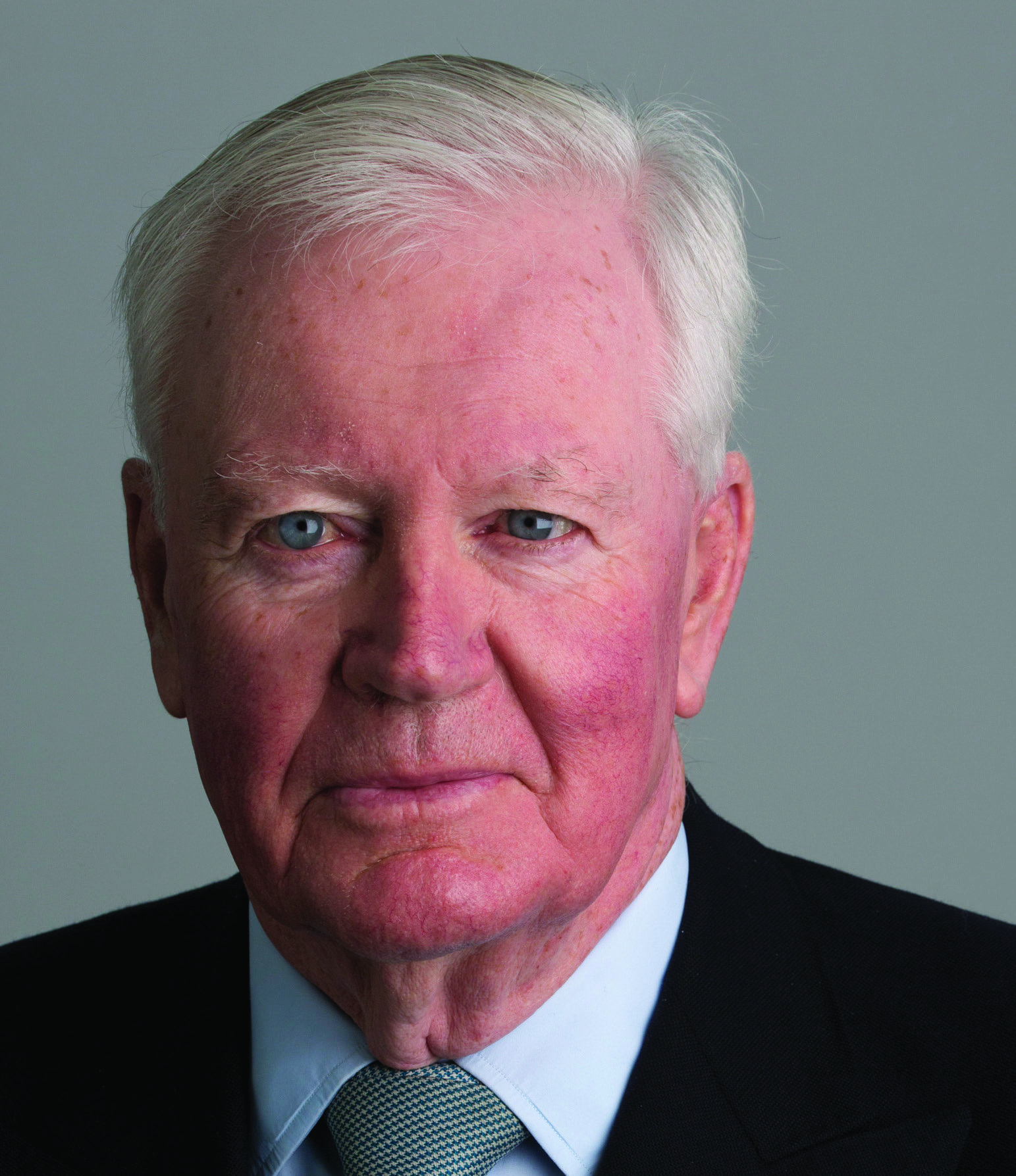 Headshot of Sir Win Bischoff, an older man with white hair, in a suit.
