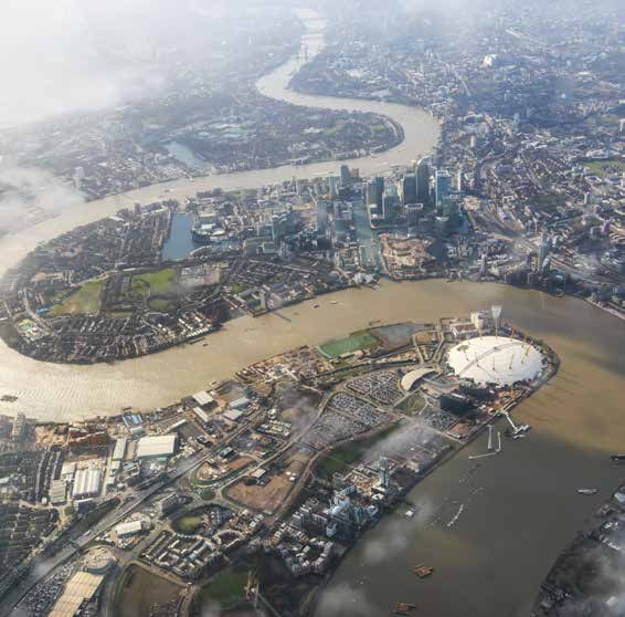 Aerial view of the River Thames snaking through London, showing Canary Wharf skyscrapers and the O2 Arena in the foreground.